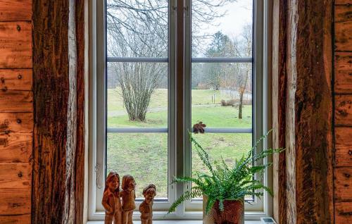 a window with a potted plant and figurines in front of it at Lovely Home In Tjörnarp With Wifi in Tjörnarp