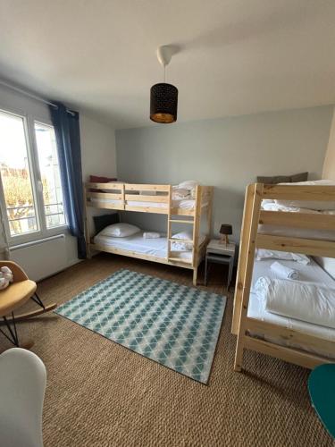 une chambre avec deux lits superposés et un tapis dans l'établissement L'entre nous, Superbe Maison au centre de St Aignan, à Saint-Aignan