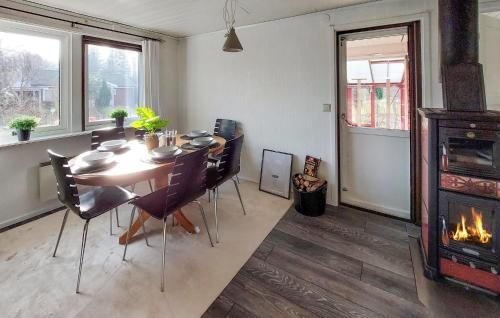 a dining room with a table and a fireplace at Amazing Home In Örkelljunga With Wifi in Orkelljunga