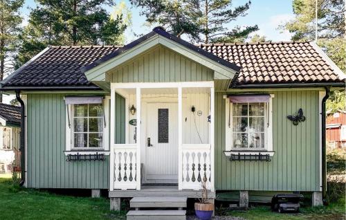 a green house with a white door and windows at Cozy Home In Väse With Wifi in Väse