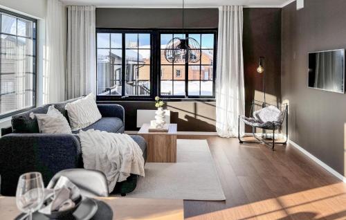 a living room with a blue couch and a large window at Stunning Apartment In Idre With Sauna in Idre