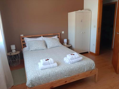 a bedroom with a bed with two towels on it at Casa do Vale in Apúlia