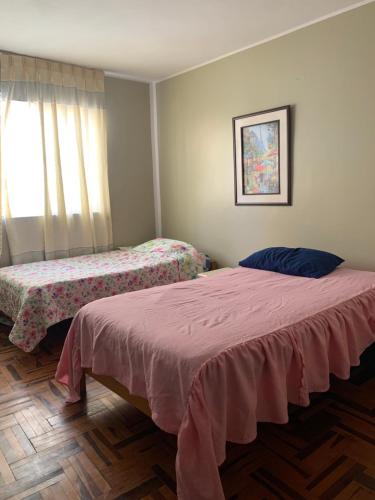 1 dormitorio con 2 camas y ventana en Habitación doble, en Pisco