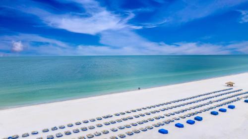 a row of blue beach umbrellas on the beach at RumFish Beach Resort by TradeWinds in St. Pete Beach