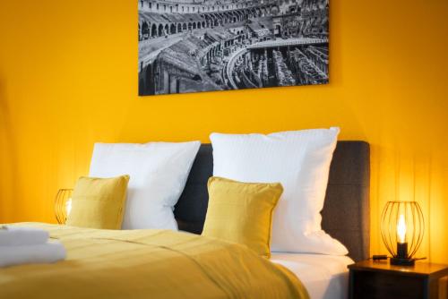 a bed with white pillows and a picture on the wall at FREE LIVING - City Design Apartments, Zentrum, Outlet, Balkon, Küche in Wolfsburg