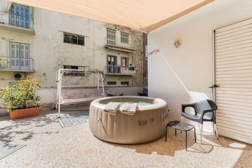 a hot tub sitting on a patio with a chair at Amazing 3BDR Apt with Unique Roof Garden in Plaka in Athens