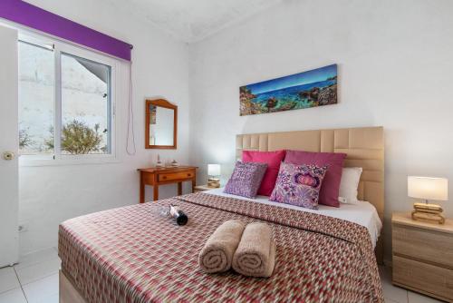 1 dormitorio con 1 cama con 2 toallas en Faro de Sardina Frente al Mar, en Gáldar