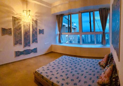 um quarto com uma cama e uma grande janela em A Night in PÂRIS on the 31st Floor em Yelahanka