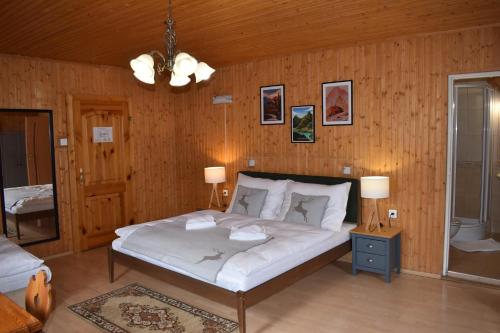 a bedroom with a large bed in a wooden wall at Drevenica Diana in Ždiar