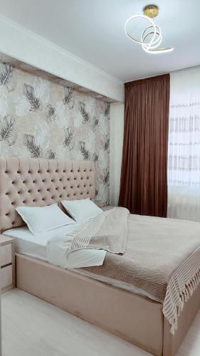 a bedroom with a large bed with a large headboard at Mountain View One in Tashkent