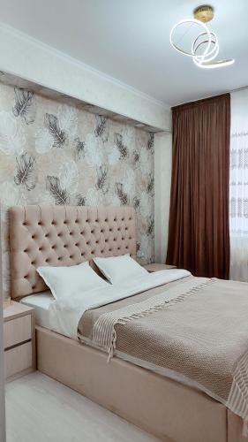 a bedroom with a large bed with a large headboard at Mountain View One in Tashkent