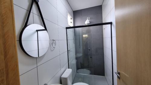 a bathroom with a shower and a toilet and a mirror at Achei Casa 6: Seu espaço exclusivo em Porto Velho in Porto Velho