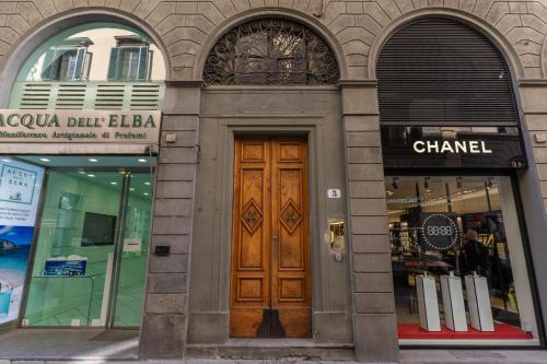um edifício com duas janelas arqueadas e uma porta de madeira em La Rosa em Florença