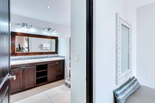 a bathroom with a sink and a mirror at Rooftop balcony oceanfront PH condo with King beds in Jacó