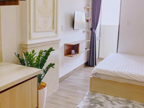 - une chambre avec un lit et une plante dans l'établissement Căn hộ ngoại ô - Phương Nam 1 Hotel & Apartments, à Hà Quảng (4)
