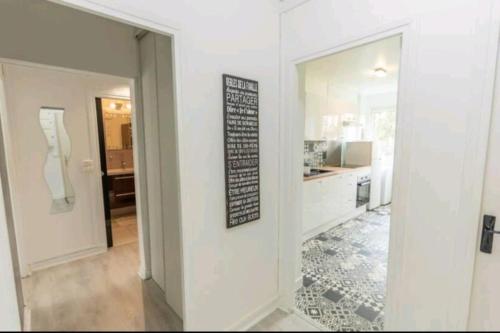 Cette chambre blanche dispose d'une cuisine et d'un miroir. dans l'établissement * Cosy & Spacieux * (75 M2) RER D à 5 min à pied, à Corbeil-Essonnes