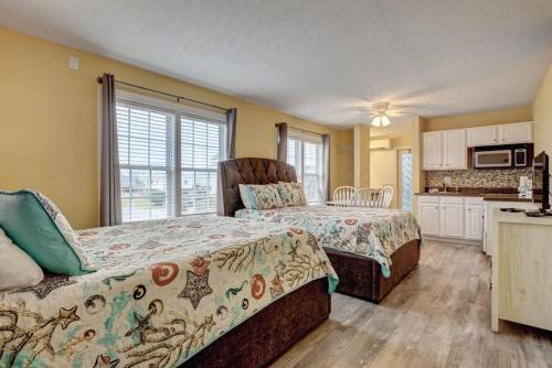 a bedroom with two beds and a kitchen at Unit 112D at Tiffany's in Surf City