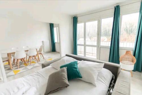 un salon avec un canapé blanc et une table dans l'établissement * Cosy & Spacieux * (75 M2) RER D à 5 min à pied, à Corbeil-Essonnes