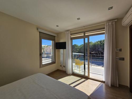 a bedroom with a bed and a sliding glass door at Antonia in Can Picafort