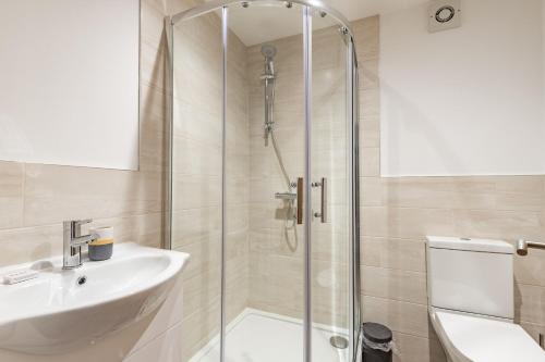 een badkamer met een douche, een wastafel en een toilet bij Number Five Hardwood Knoll House in Cromer