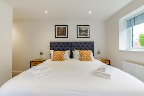 a bedroom with a large white bed with two pillows at Number Five Hardwood Knoll House in Cromer