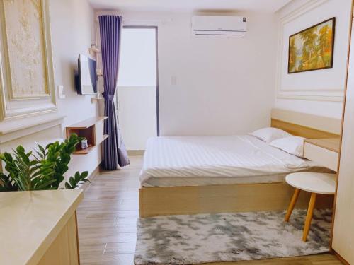 Hà Quảng (4)にあるCăn hộ ngoại ô - Phương Nam 1 Hotel & Apartmentsの小さなベッドルーム(ベッド1台、テーブル付)