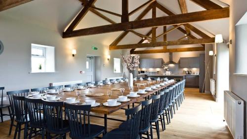 a long dining room with a long table and chairs at Manifold Barns in Belper