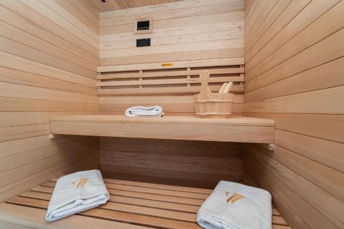 a sauna with two white towels sitting on a wooden shelf at Luxury Villa Kaia with heated pool and SPA in Vodice