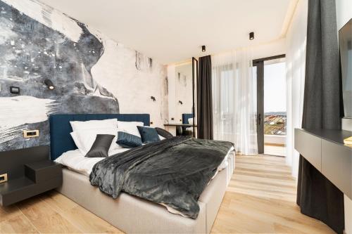 a bedroom with a bed and a large painting on the wall at Luxury Villa Kaia with heated pool and SPA in Vodice