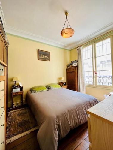 une chambre avec un grand lit et une fenêtre dans l'établissement Excellence YourHostHelper, à Paris