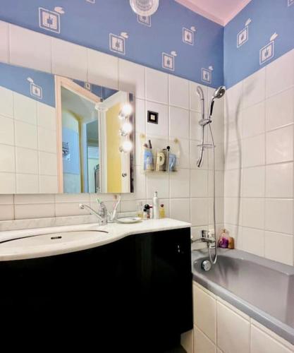 une salle de bain avec un lavabo et un miroir dans l'établissement Excellence YourHostHelper, à Paris