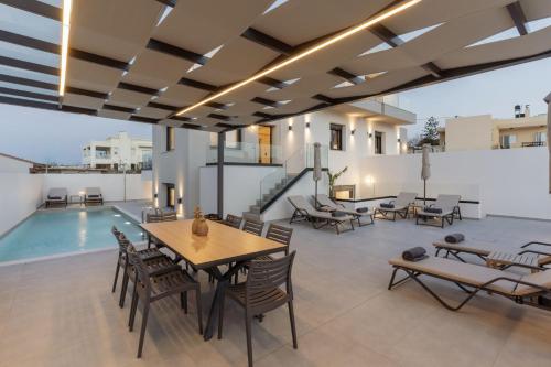 a patio with a table and chairs and a pool at Villa Aelia - With Private Pool & Sauna in Pigi