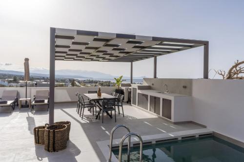 a patio with a table and chairs and a swimming pool at Villa Aelia - With Private Pool & Sauna in Pigi