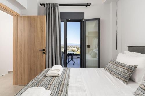 a bedroom with a white bed with a view of a table at Villa Aelia - With Private Pool & Sauna in Pigi