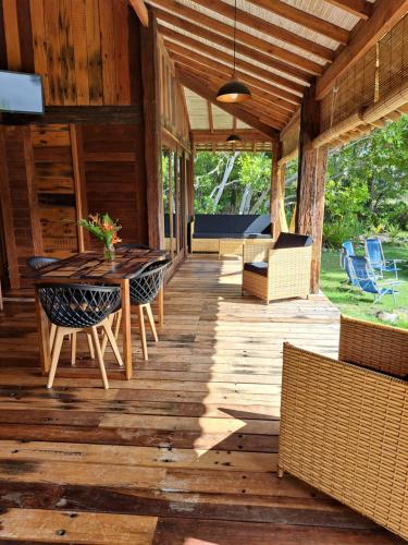 a porch of a house with a table and chairs at Woodstock Bungalow - Barra Grande - condo frente praia in Barra Grande