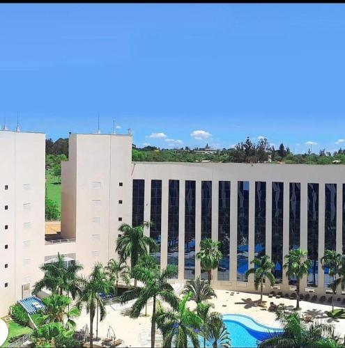 a view of a building with a pool and palm trees at 1233 in Barretos