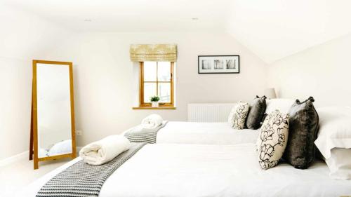 a bedroom with two white beds and a mirror at Lapwing Barns in Longnor