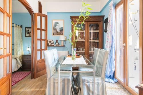 ein Esszimmer mit einem Glastisch und weißen Stühlen in der Unterkunft Piccolo e intimo centro città in Nuoro