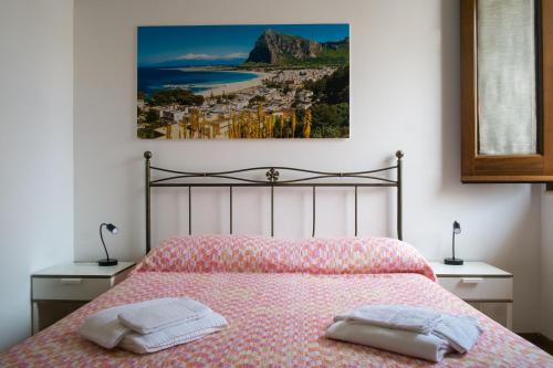 サン・ヴィート・ロ・カーポにあるAppartamenti Leoneのベッドルーム1室(ベッド1台、タオル2枚付)