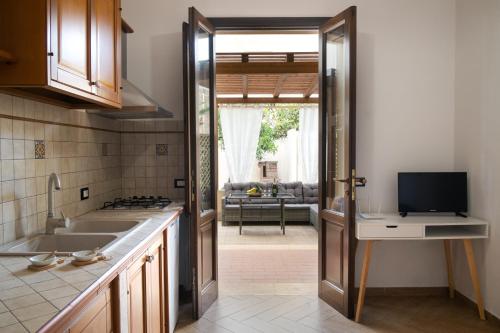a kitchen with a door open to a living room at Appartamenti Leone in San Vito lo Capo