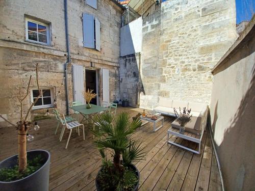 une terrasse avec un canapé, une table et des chaises dans l'établissement Maison très agréable et calme avec terrasse en centre ville, à Angoulême