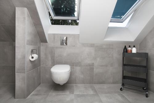 a bathroom with a toilet and some windows at Villastadens Pendlarbostad in Gävle