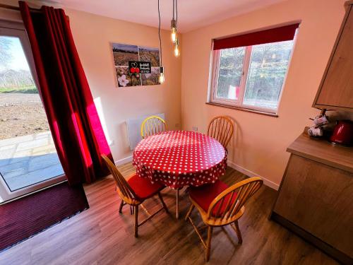 a dining room table with chairs and a red polka dot at Cherry Lodge in Godshill