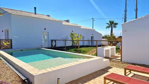 a swimming pool in the backyard of a house at Milagres de Santa Rita in Vila Nova De Cacela
