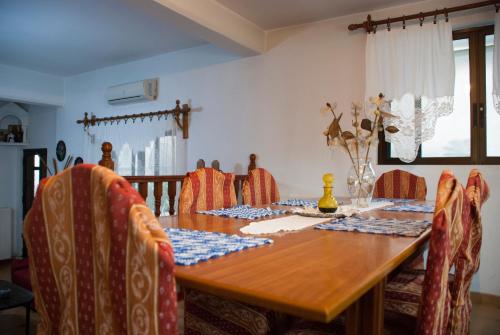 a dining room table with chairs and a wooden table at Gaia garden house in Gáïa