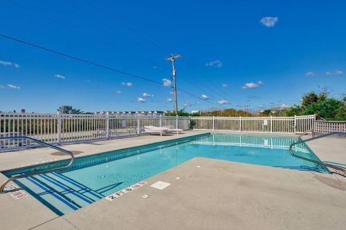 een zwembad met een wit hek en een blauwe lucht bij Unit 115SD at Tiffany's in Surf City