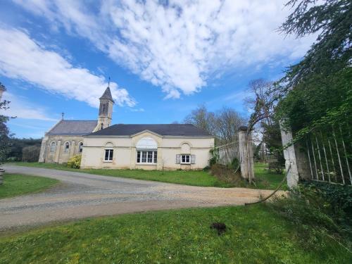 an old house with a church on a road at Gite de la Chapelle - Circuit des 24 heures - ARNAGE - 10 personnes in Les Loges