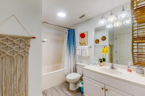 a bathroom with a toilet and a sink and a mirror at Majestic Beach Resort Tower 1 #915 in Panama City Beach