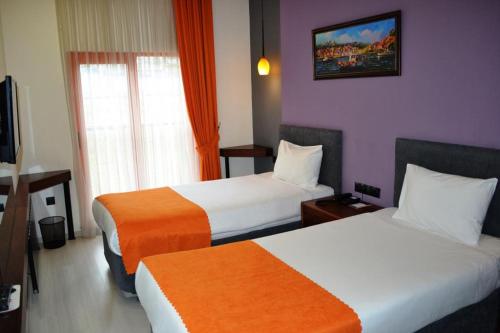 a hotel room with two beds and a tv at D&D HOTEL in Nilüfer