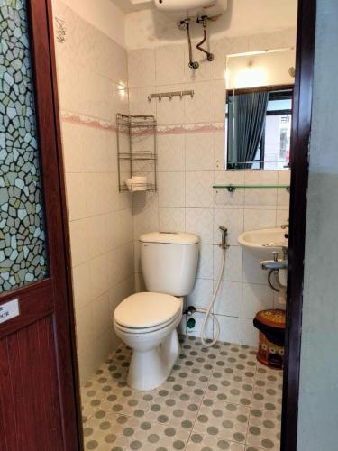 a bathroom with a toilet and a sink at RICE HOUSE HUE in Hue